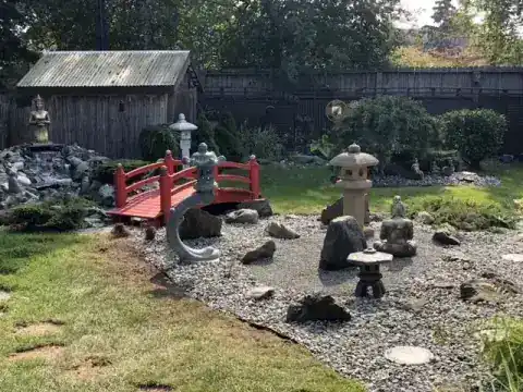Japanese garden with a red arched bridge, stone lanterns and rock work